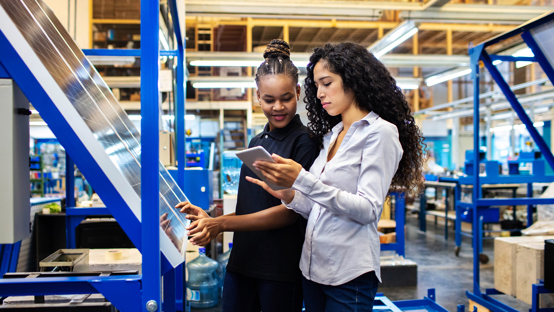 Women looking at a tablet in a manufacturing plant