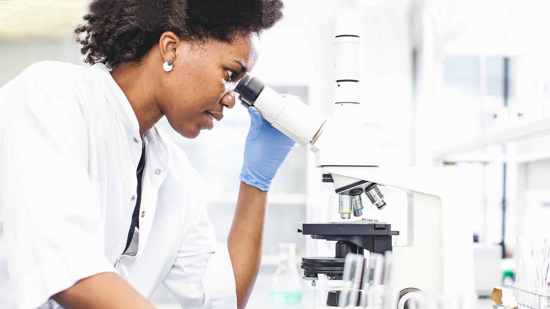 Woman examining a sample under a microscope